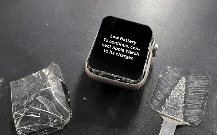 Apple Watch reparado junto al cristal roto que se retiró y el cristal nuevo instalado